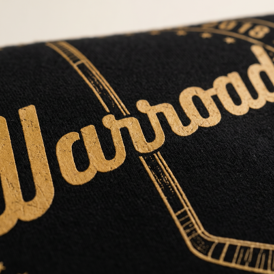 Decoration macro: close macro of the gold cursive "Warroad" chest print on dense black fleece. - image 3