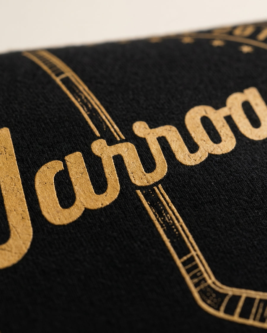 Decoration macro: Close macro of the gold cursive "Warroad" chest print on dense black fleece. - image 3