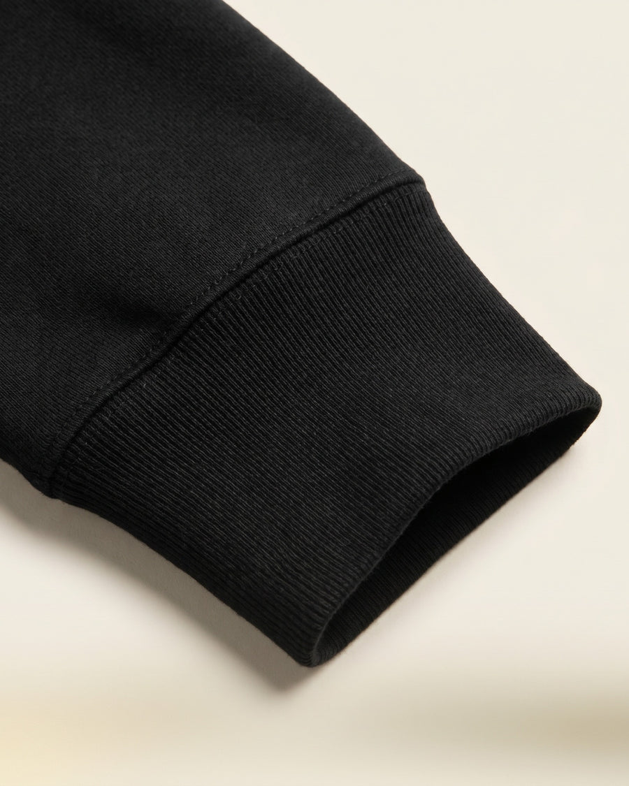 Cuff: Close-up of the ribbed cuff showing the dense, substantial black fleece. - image 5