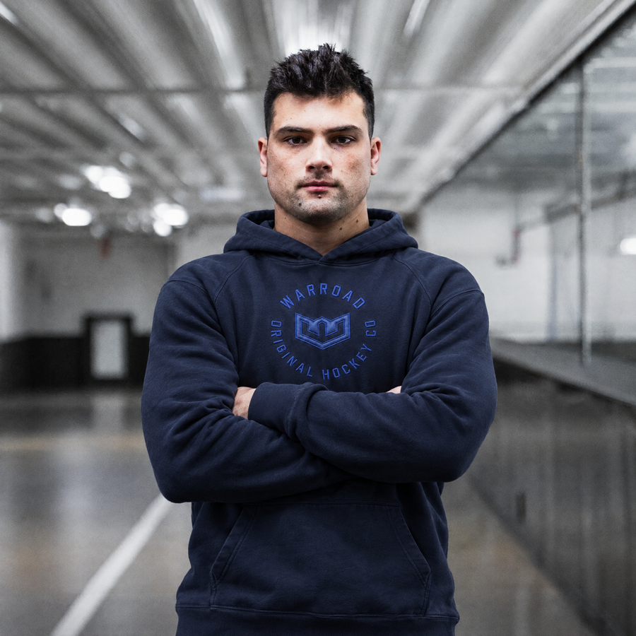 Crest Pullover Hoodie in Royal Navy worn, arms crossed - image 4